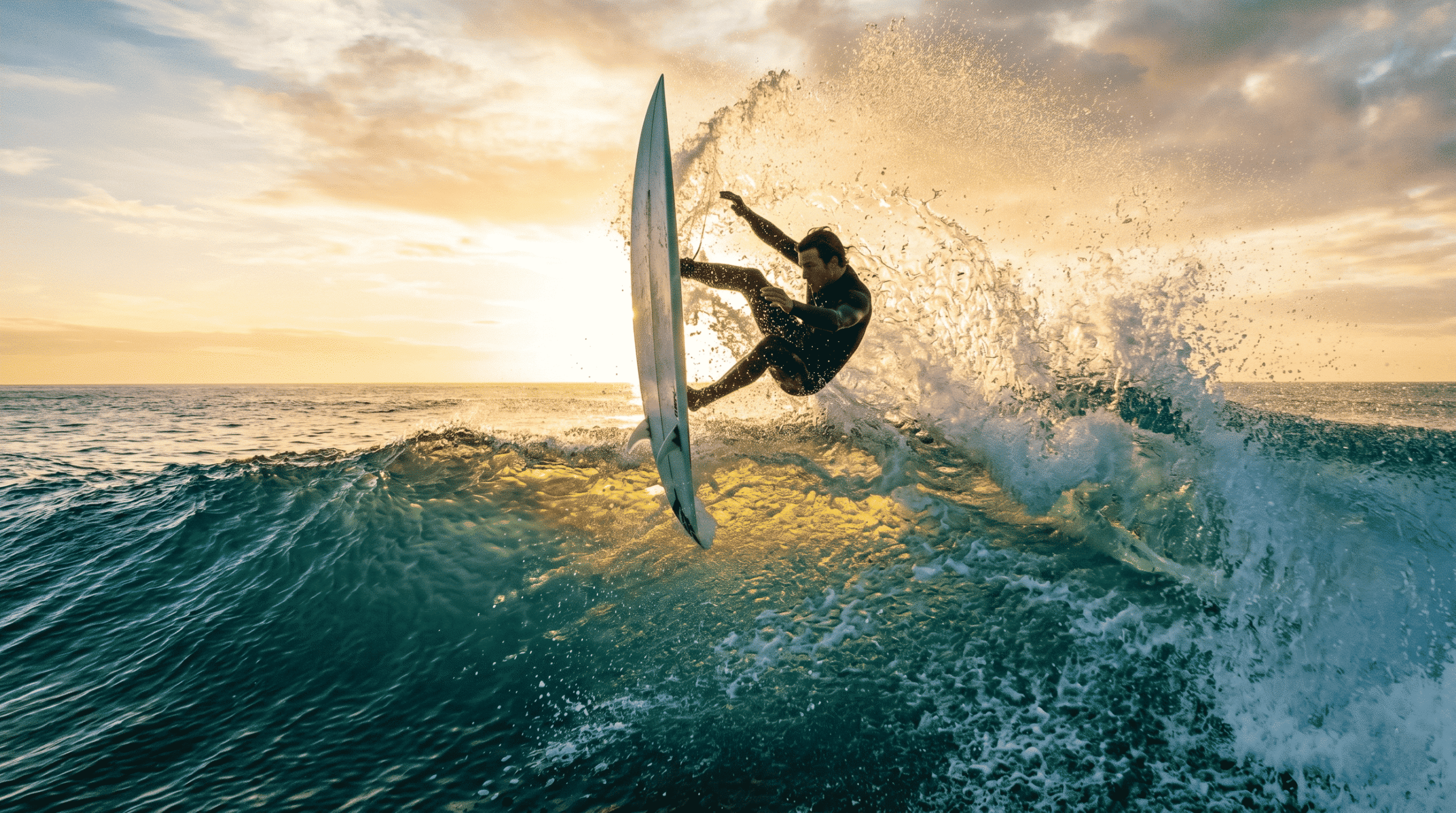 High-performance surf maneuvers: An experienced surfer striking the vertical lip of a wave during a powerful re-entry.
