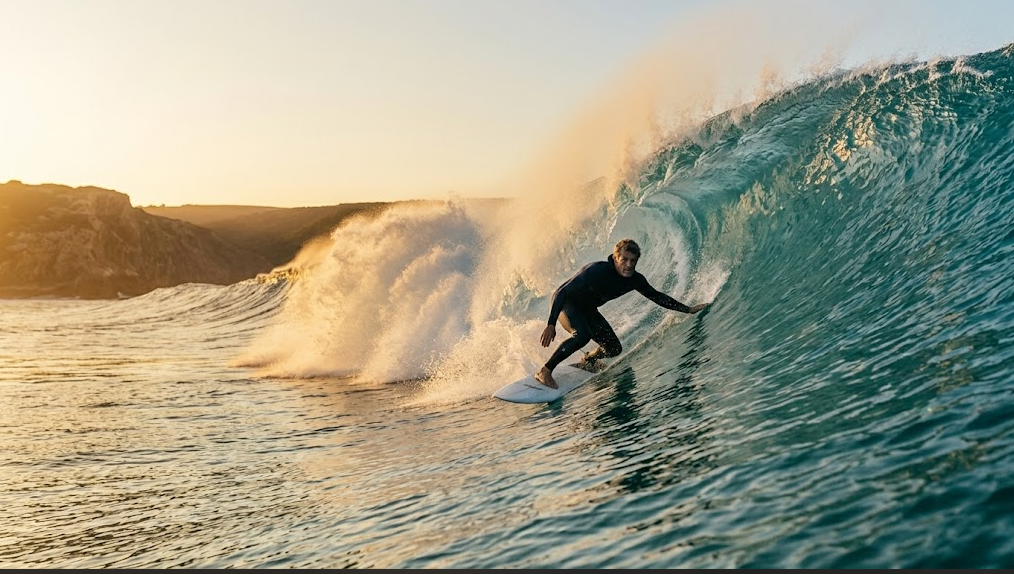 Surf Techniques for Intermediate Surfers: experienced surfer leaning into a powerful forehand bottom turn at the transition zone of a wave.